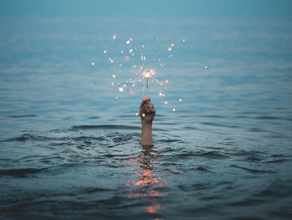 underwater hand holding a sparkler